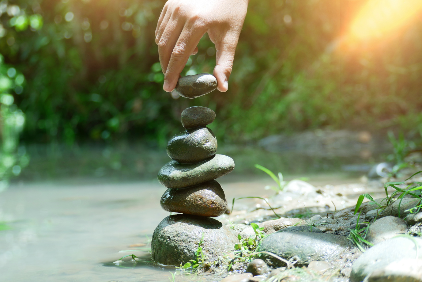 Banlance stone with spa with hand holding stone on nature blur background