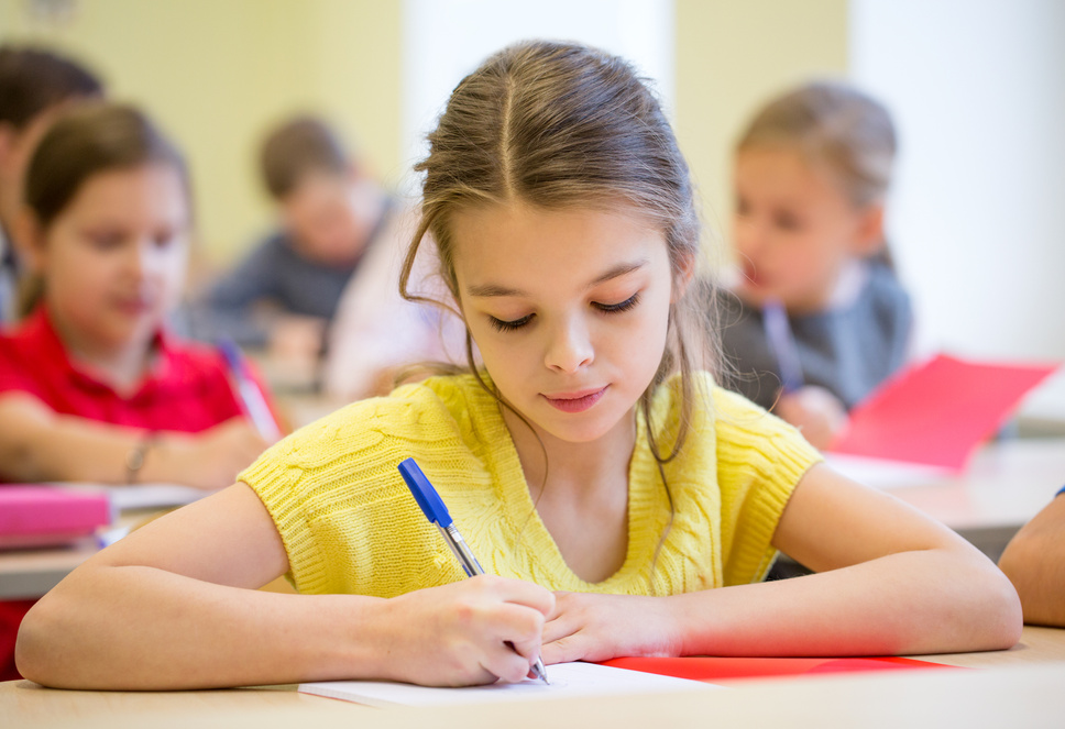 Group of School Kids Writing Test in Classroom