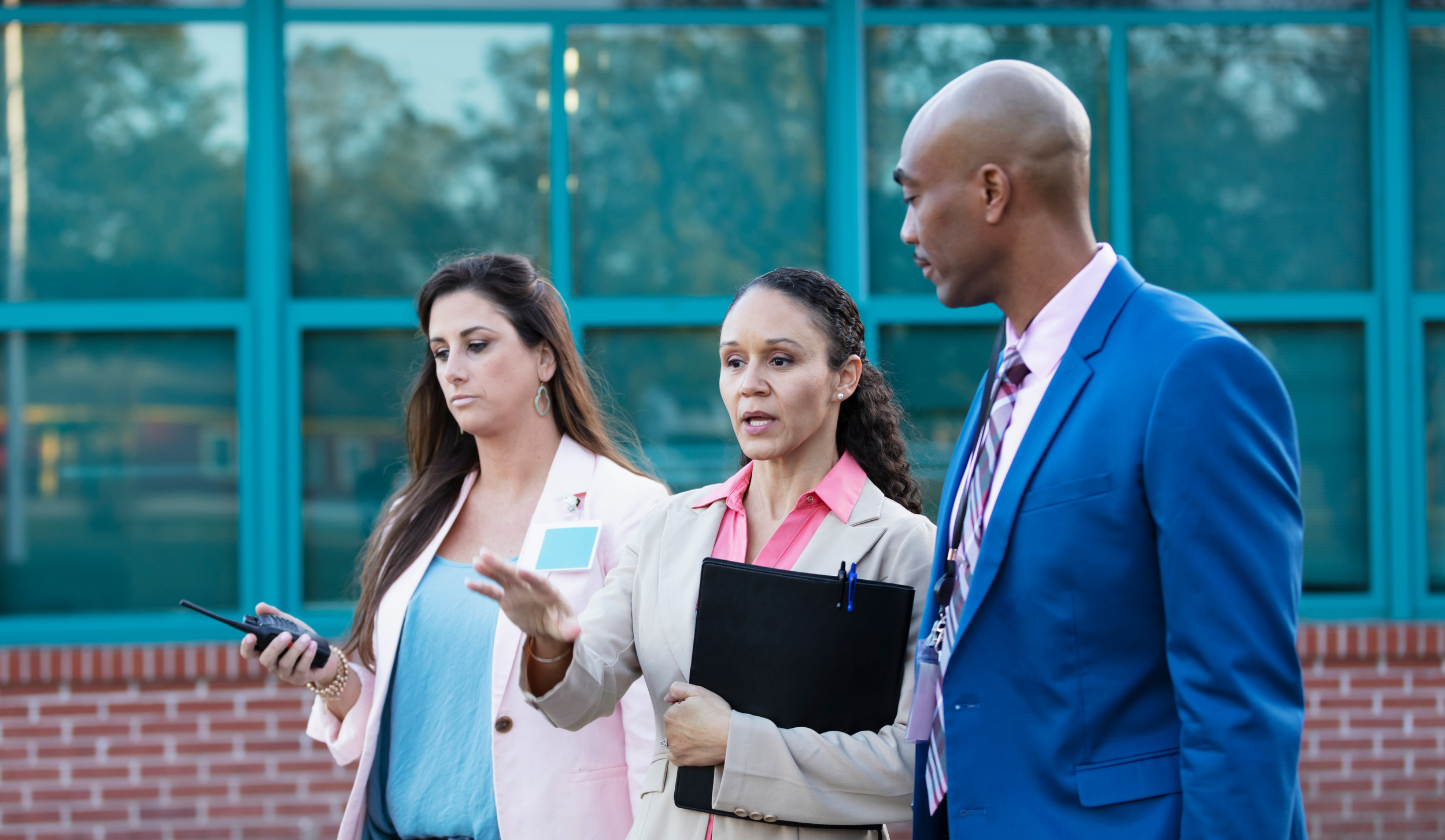 Teachers and principal talking outside school building